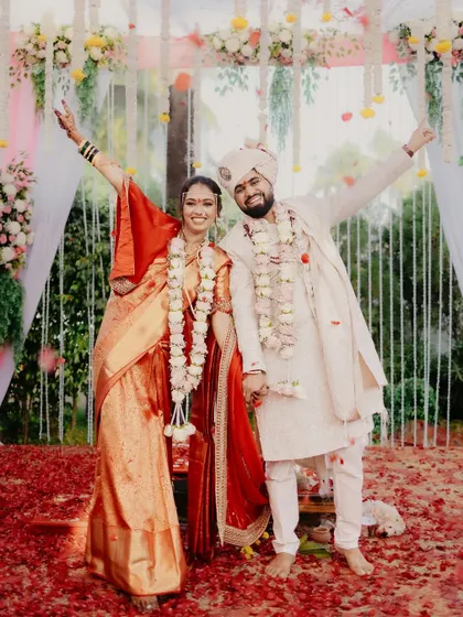 The newly married couple strikes a pose of triumph and joy after their wedding ceremony.