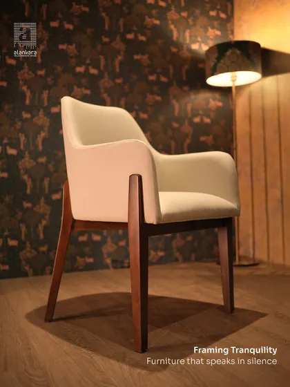 This dining armchair combines ergonomic comfort with quiet luxury. The cream upholstery and angled wooden legs create a silhouette that is both modern and elegant.
