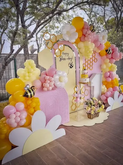 A cheerful "Happy Bee-day" party setup, bursting with yellow and pink balloons, honeycomb details, and cute bee accents. I design these vibrant themes to be fun, playful, and completely photo-ready.