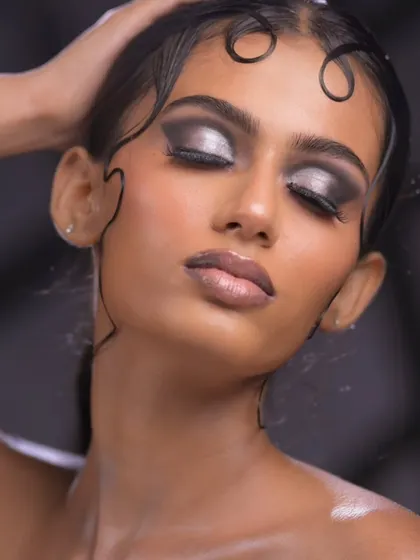 The eyes-closed shot provides a full view of the intricate silver and black eyeshadow blending.