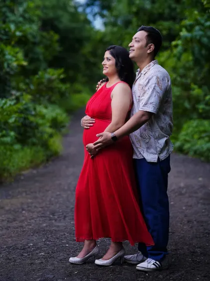 A classic couple's pose during an outdoor maternity shoot. They stand together looking towards the future, surrounded by the beauty of nature.