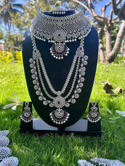 A modern and elegant reception set with a silver finish and dark purple stones. This rental includes a choker, a four-layer long necklace, and matching earrings.