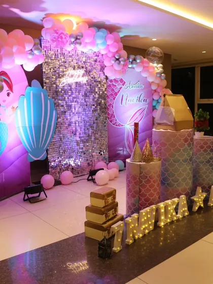 A magical mermaid-themed birthday decoration for Anvika. This setup includes a sparkling sequin wall, custom mermaid backdrops, themed cutouts, and a colorful balloon arch to create an underwater fantasy world.