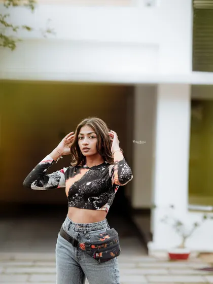 A confident pose from the same outdoor session. The clean background helps the model and her colorful top stand out.