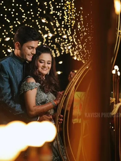 An artistic shot of the couple during their sangeet, using foreground blur to create a dreamy, intimate feel.