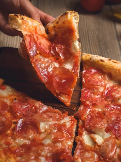 Grabbing a slice of the Truffle Salami pizza. The perfect way to treat yourself.