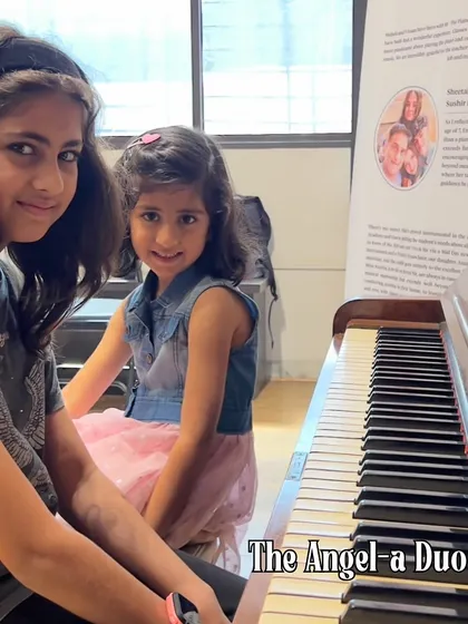 An angel-a-duo. Two sisters share a moment at the piano, representing the joy of learning music together. We encourage siblings to join our classes and share their musical journey.