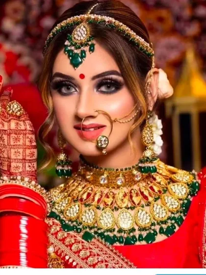 This heavy Polki bridal set with green and red accents is a statement piece. It includes a choker, matha patti, and nath, all available for purchase.