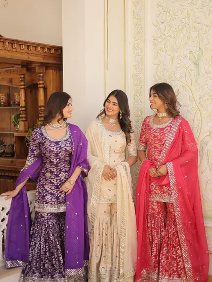 A trio of sharara sets in purple, cream, and pink. These are great options for a coordinated bridesmaid look, offering a uniform style in different colors to suit each person.