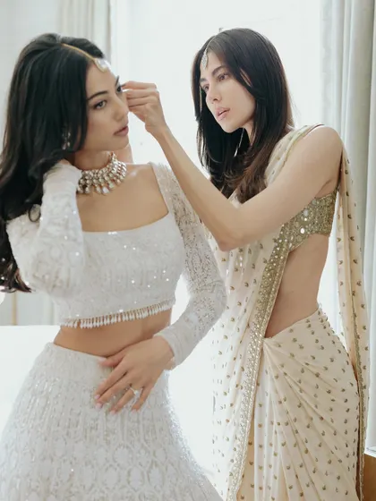 A behind-the-scenes moment of Julia getting ready with her sister. This image captures the intimacy and support of family on the wedding day.