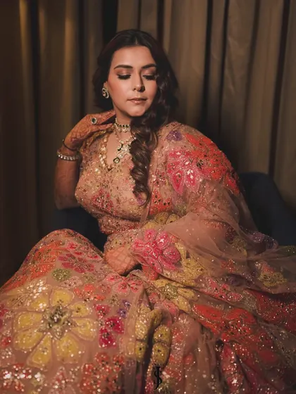 A close-up of the bride's stunning Sangeet look. The layered jewelry adds a playful and modern touch to her floral lehenga.