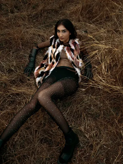 A full-length reclining pose in a natural setting. This shot has a relaxed yet high-fashion feel, perfect for a lookbook.