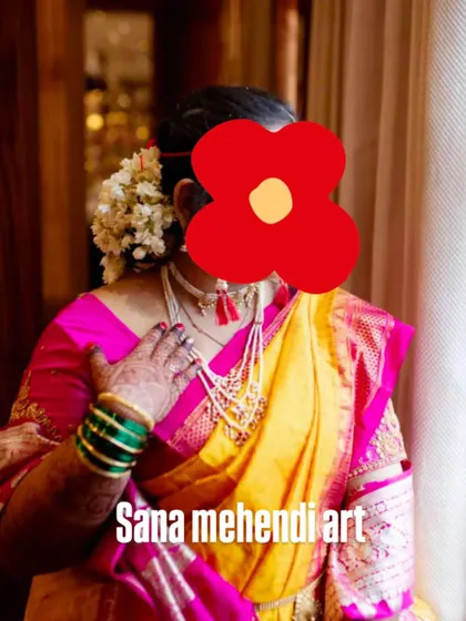 A candid shot of a bride in a traditional Maharashtrian Paithani saree, with her mehendi visible.