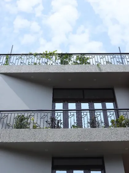 Another angle of the Ram's Anugraham facade, highlighting the clean lines, functional balconies with planters, and the simple yet elegant railing design.