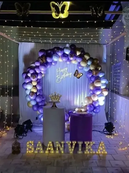 Our butterfly theme creates a magical and whimsical atmosphere. This beautiful terrace canopy setup for Saanvika's birthday features purple and gold balloons, fairy lights, and delicate butterfly accents.