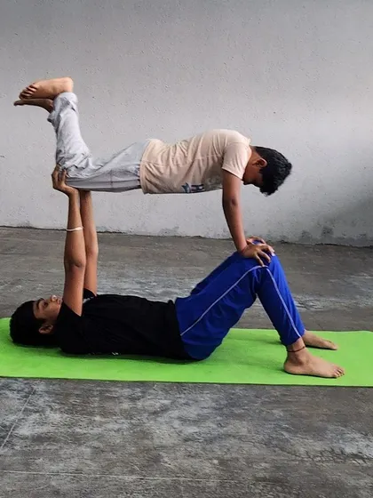 A classic "bird" pose in acro-yoga, requiring strong legs from the base and a straight, engaged body from the flyer.