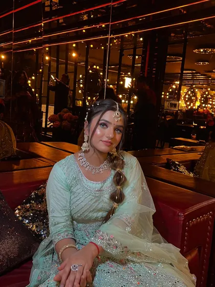 This shot highlights the unique bubble braid hairstyle, a modern and fun choice for a party. The makeup is kept soft, with a focus on glowing skin and bright eyes.