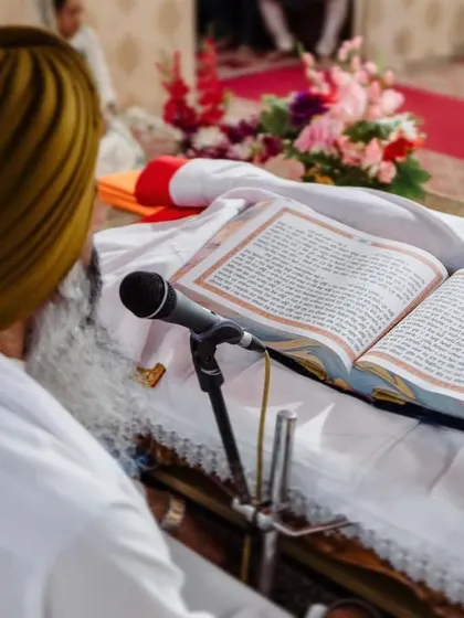 A shot focusing on the Guru Granth Sahib during a Sikh wedding ceremony. We respectfully document the religious and cultural details of your wedding.
