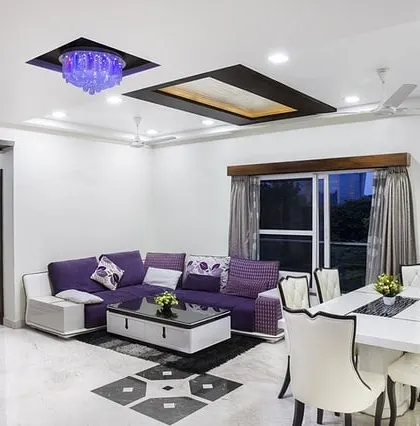 A spacious living and dining area with crisp white walls and detailed ceiling work. A flawless white coat is essential for a bright, clean, and modern home.