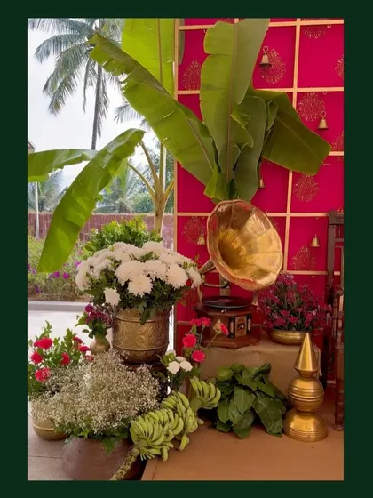 A traditional decor corner featuring a brass gramophone, banana leaves, and fresh flowers, blending natural and vintage elements perfectly.