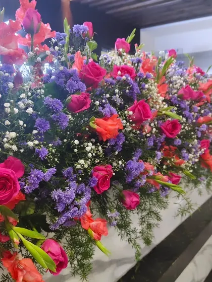 A close-up of a vibrant flower arrangement featuring roses, gladiolus, and baby's breath. I use only fresh flowers for my decor.