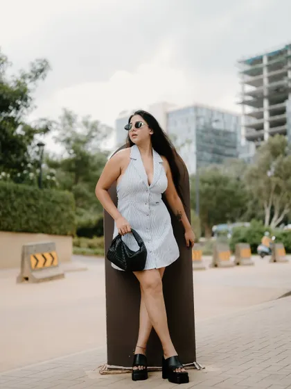 A full-length fashion portrait with the Bangalore cityscape in the background. The model's pose and the urban environment create a stylish and contemporary image.
