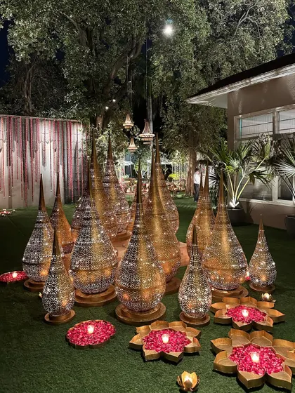 A collection of our golden filigree lanterns, creating a beautiful installation on the grass.