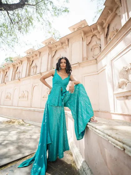 We get the pressure to look perfect at a big Indian wedding, even as a guest. This turquoise sharara set with its peplum top and mirror work is a fun, fashionable piece you can borrow without the stress of buying. Wear it, return it, and repeat.