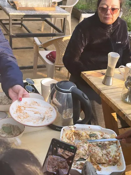 Guests enjoying a meal together at our long community table. Dining at the farm is a shared experience, perfect for making new friends who share a love for nature and good food.