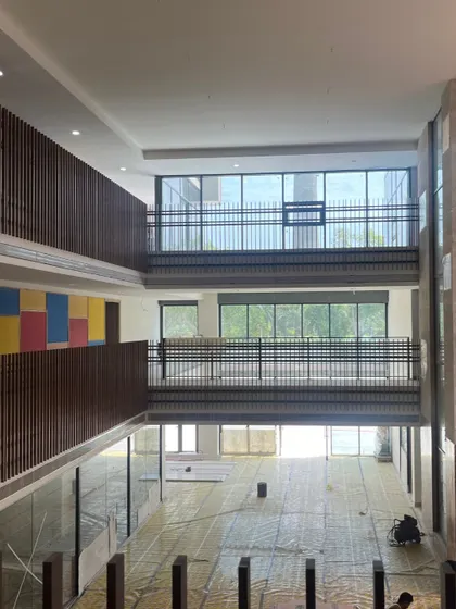 An under-construction view of a multi-story atrium in a new school. This shows the bare structure and scale of the space before final finishes are applied, highlighting the visual connections between floors.