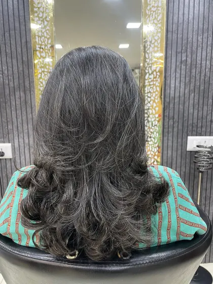 This layered haircut with soft inward curls was created by a student. It's a classic look that adds volume and dimension, especially to straight or fine hair.