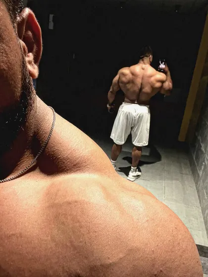 An artistic over-the-shoulder shot showing back and trap development.