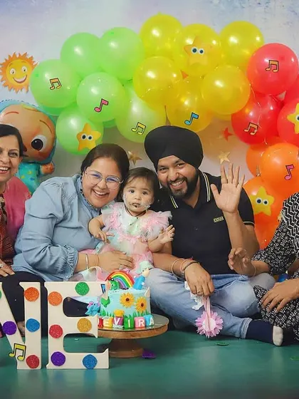 The whole family is here to celebrate! Grandparents, parents, and aunts all joined in for this happy Cocomelon-themed family photo.