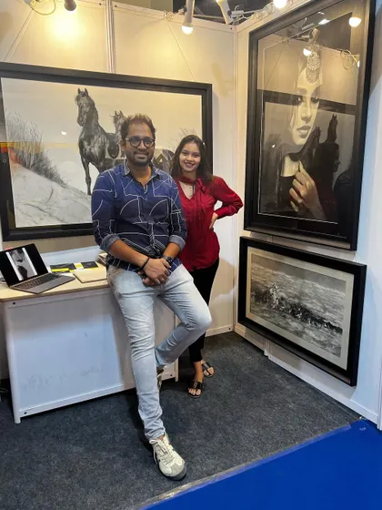 Posing with a visitor at my exhibition booth, surrounded by my large horse and portrait artworks.