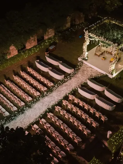 An aerial view of a nighttime wedding setup, showing the grand scale of the mandap and guest seating arrangement.