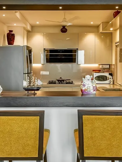 This C-shaped acrylic kitchen includes a breakfast counter, seamlessly connecting the kitchen to the living area. It's a perfect example of how we design spaces that are both functional and social.