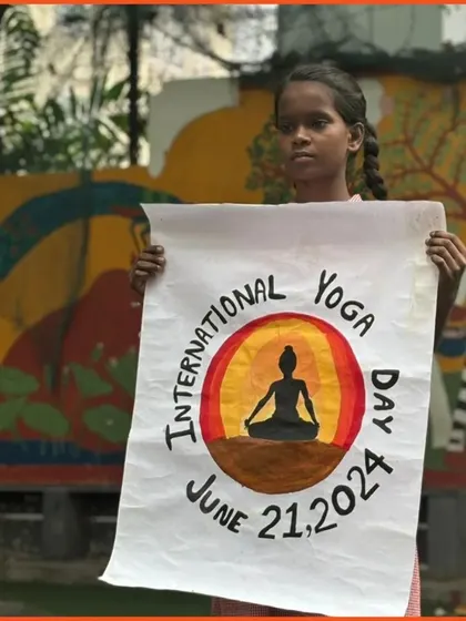 A young girl holds up a handmade poster for International Yoga Day. Art and creativity are wonderful ways to engage children and celebrate the spirit of wellness.