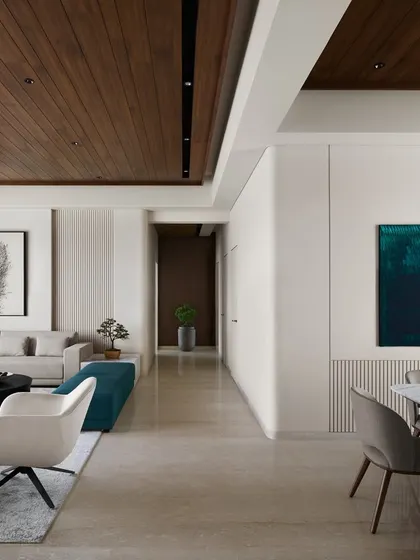 The living and dining areas of Lumen House are unified by a 12-foot ceiling and warm wood paneling, creating an expansive feel. We used pops of teal in the ottoman and artwork to add a cool contrast to the neutral, light-filled space.