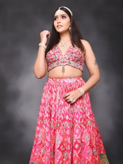 A full-length view of the modern-traditional fusion look. The vibrant pink lehenga is paired with bold, creative makeup for a stunning photoshoot.