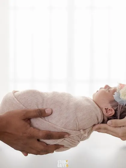 A precious newborn held gently in the hands of their parents, symbolizing the beginning of their family's journey.