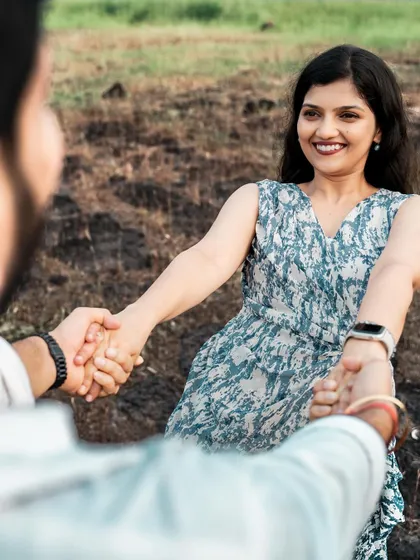A sweet, candid moment of a couple holding hands, with the focus on the bride's happy expression.