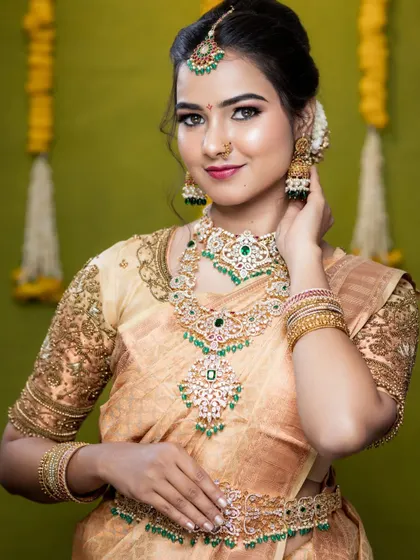 A beautiful South Indian bridal look created by a makeup artist using my jewellery. The model is wearing a Victorian-style AD stone set with green stones.
