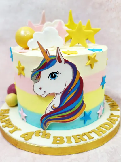 We make wishes come true with this enchanting celestial unicorn cake. A majestic unicorn is set against pastel rainbow stripes, surrounded by golden stars and fluffy clouds, creating a magical and dreamy birthday experience.