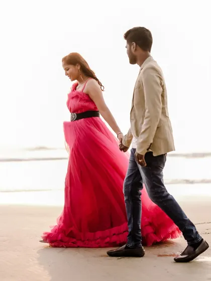 A simple and sweet moment of a couple walking on the beach. The ruffled pink gown adds a touch of playfulness and romance.