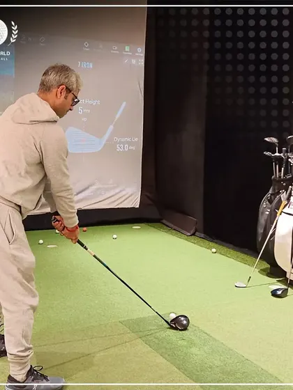 A client takes a swing in the simulator, with the data projected behind him. This shows the immersive and analytical environment of my studio.