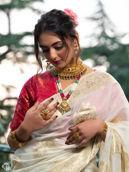 A beautiful portrait showcasing the complete traditional look, with a focus on the layered gold necklaces.