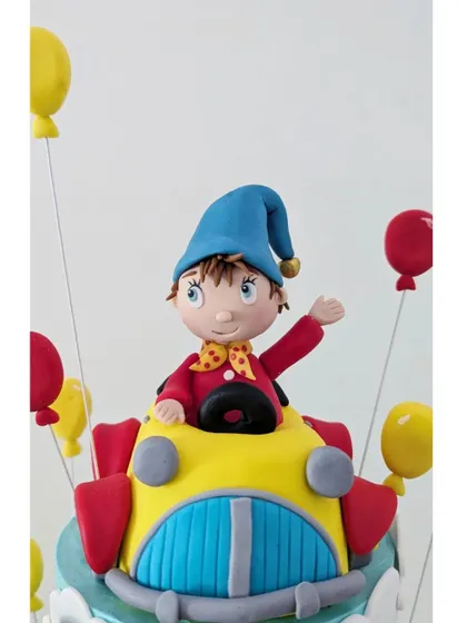 A detailed look at the Noddy figurine in his signature car, with a little bell on his hat.