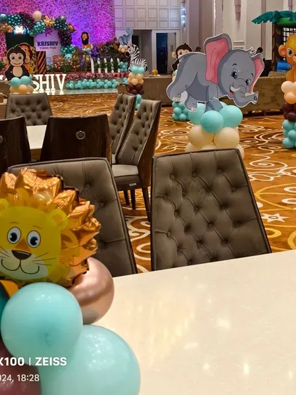 I use themed centerpieces and props throughout the venue. Here you can see the table decor and character cutouts that match the main jungle theme.
