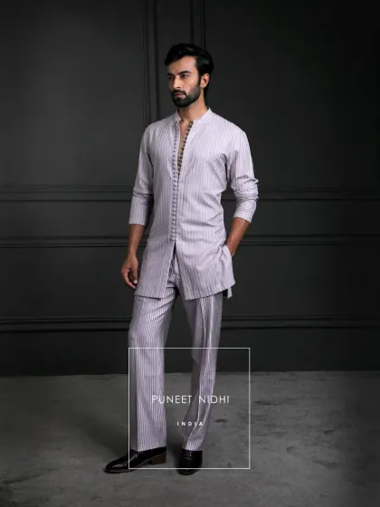 A blush pink longline kurta, tailored to perfection with a straight cut. Adorned with looped fabric buttons and a regal mandarin collar, it has heritage in its soul.