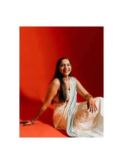 A vibrant and modern bridal portrait. The bride's joyful smile against the bold red background creates a stunning and memorable image.